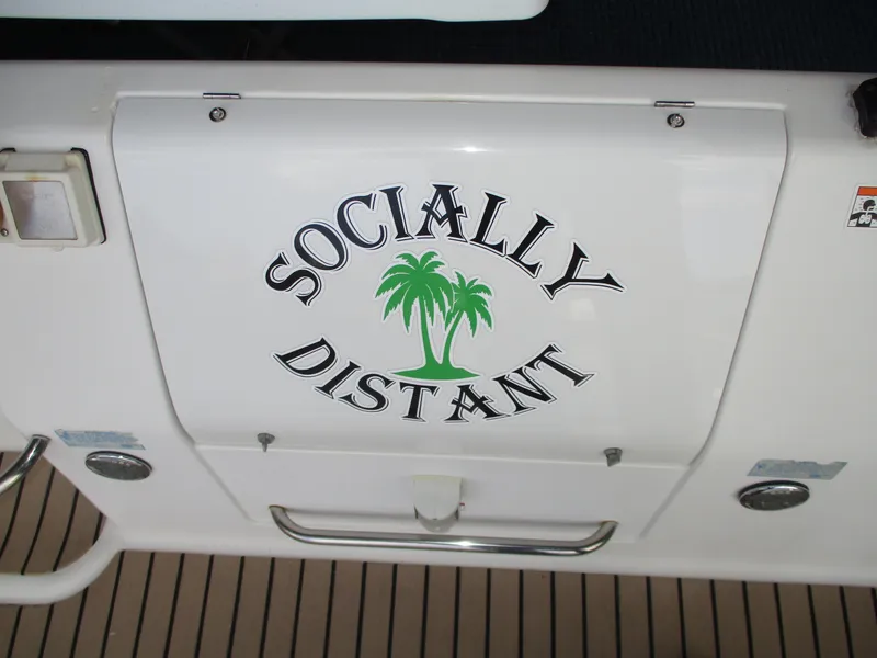 Slide: The Image of 1997 Carver Voyager boat with "Socially Distant" and palm tree graphic on the stern. - 10