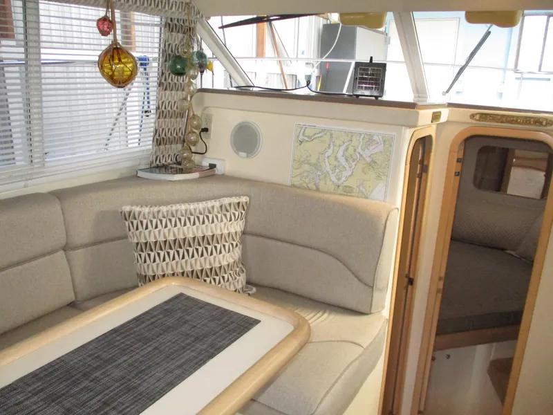 Slide: The Image of 1997 Carver Voyager interior with beige seating, decorative pillow, and nautical map. - 25