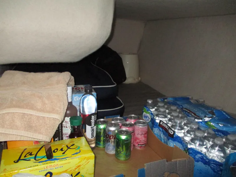 Slide: The Image of Storage area in a 1997 Carver Voyager with drinks, towels, and water bottles. - 34