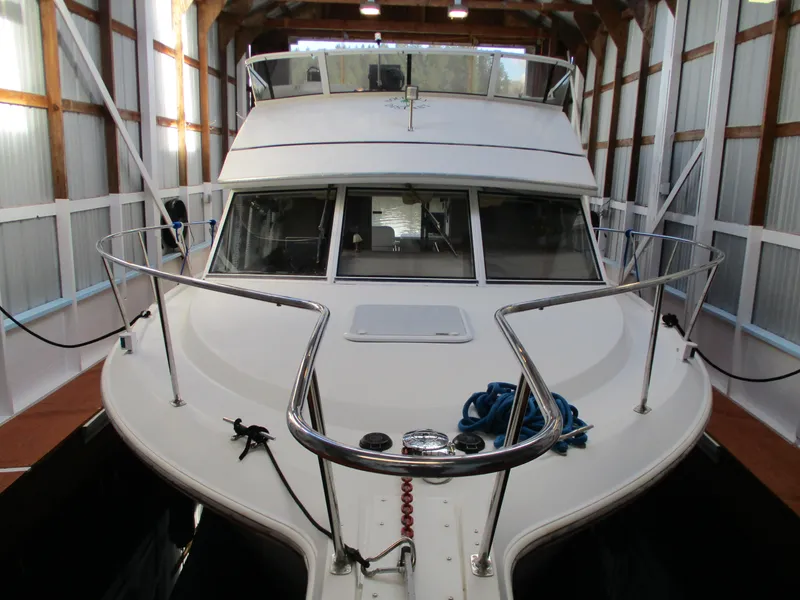 The Image of 1997 Carver Voyager boat docked in a covered marina. - 0
