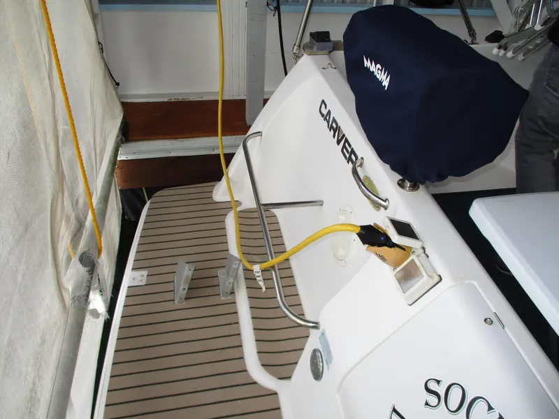 Slide: The Image of 1997 Carver Voyager boat deck with covered equipment and safety railings. - 11