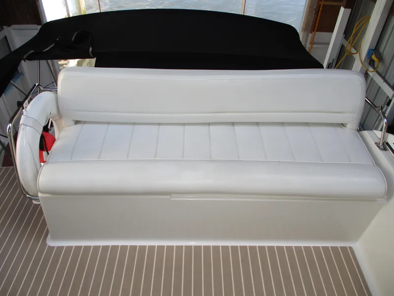 Slide: The Image of White leather seating on a 1997 Carver Voyager boat, with striped flooring. - 18