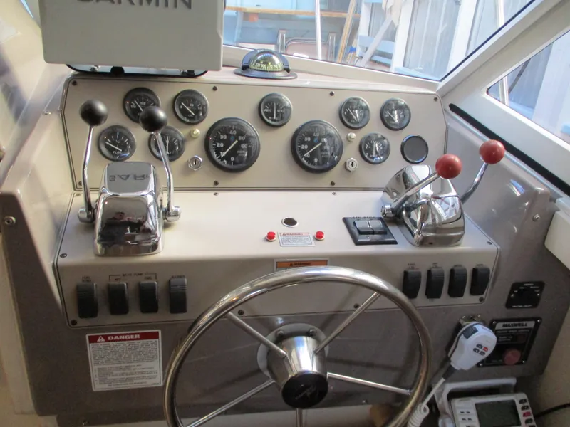 Slide: The Image of 1997 Carver Voyager helm with gauges, controls, and steering wheel. - 19