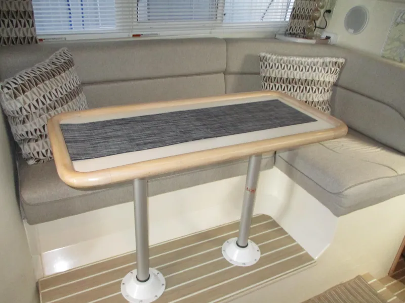 Slide: The Image of 1997 Carver Voyager interior with cushioned seating and wooden table. - 24
