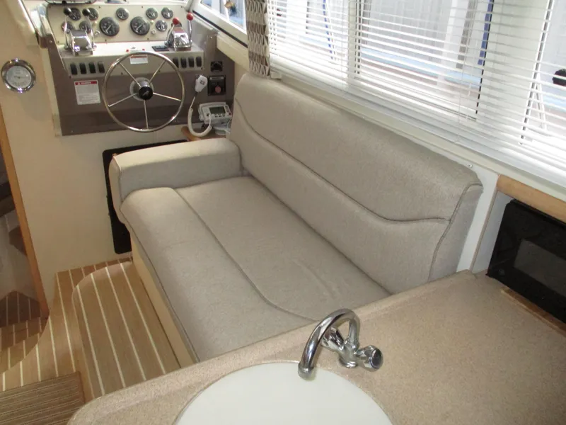Slide: The Image of Interior of a 1997 Carver Voyager boat with beige seating and steering controls. - 26