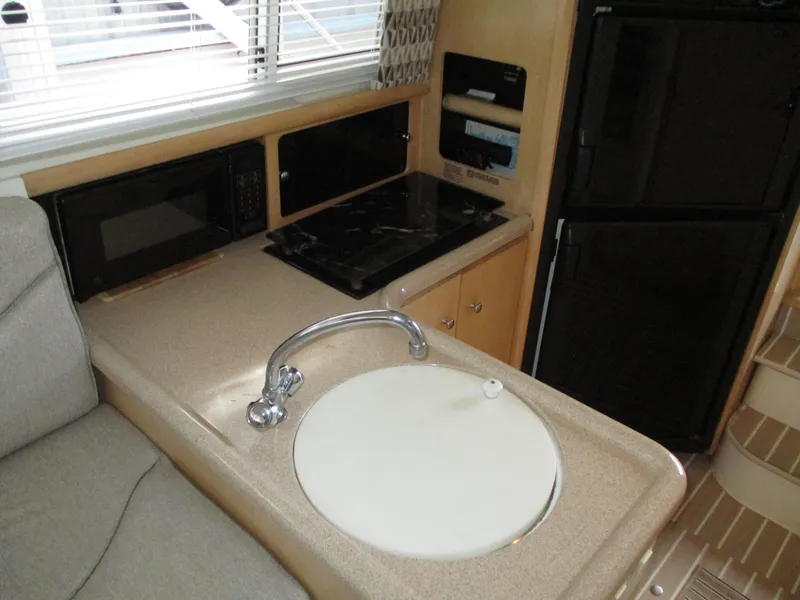 Slide: The Image of 1997 Carver Voyager kitchen area with sink, stove, microwave, and refrigerator. - 28