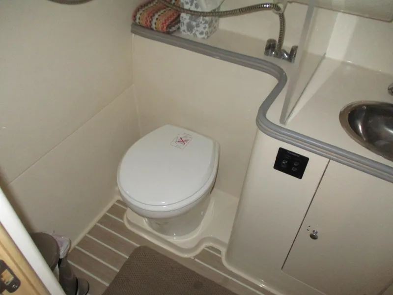 Slide: The Image of Bathroom interior of a 1997 Carver Voyager boat, featuring a toilet and sink. - 36