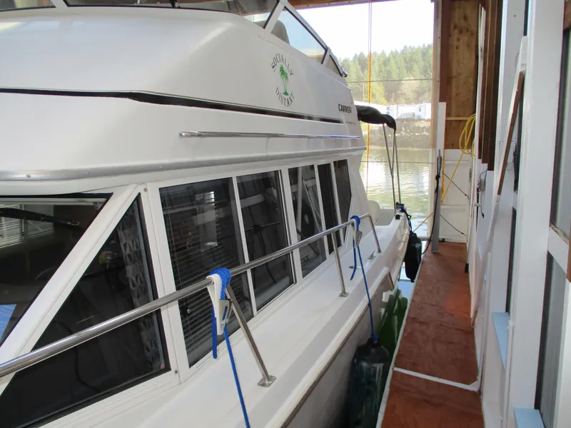 Slide: The Image of 1997 Carver Voyager docked in a boathouse, side view with windows and railing. - 9