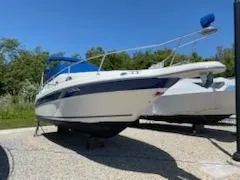 The Image of 1996 Sea Ray 270 Sundancer Special Edition boat on display outdoors. - 0