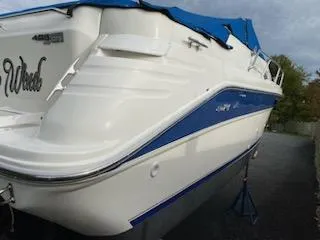 Slide: The Image of 1996 Sea Ray 270 Sundancer Special Edition boat with blue cover, docked on land. - 17