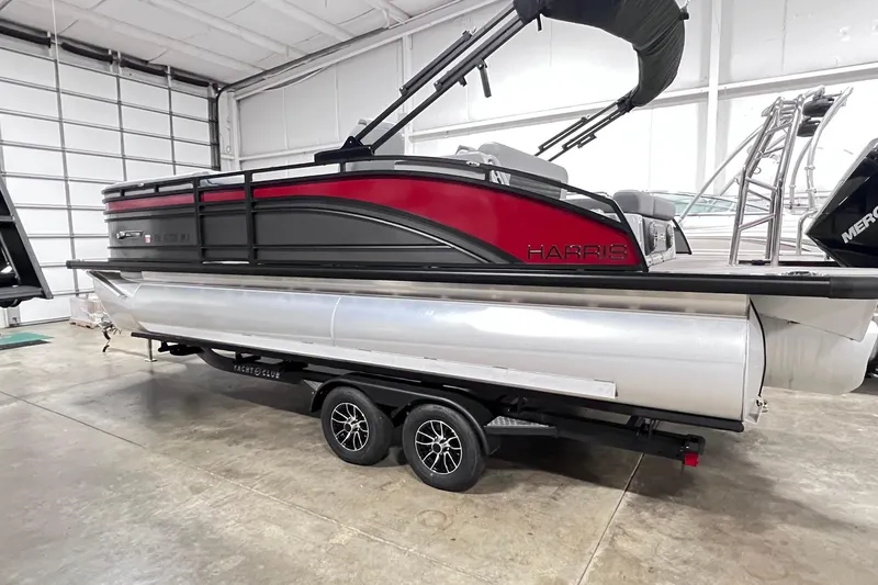 Slide: The Image of 2024 Harris Solstice 230 pontoon boat in showroom, featuring sleek design and vibrant colors. - 1