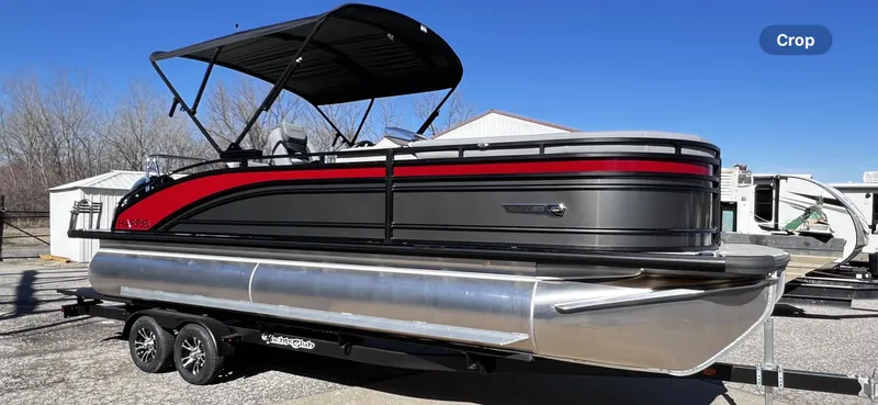 Slide: The Image of 2024 Harris Solstice 230 pontoon boat with black and red accents on a trailer. - 10