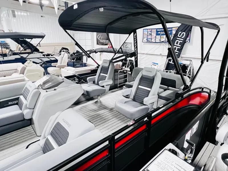 Slide: The Image of 2024 Harris Solstice 230 pontoon boat with black canopy and gray seating. - 15