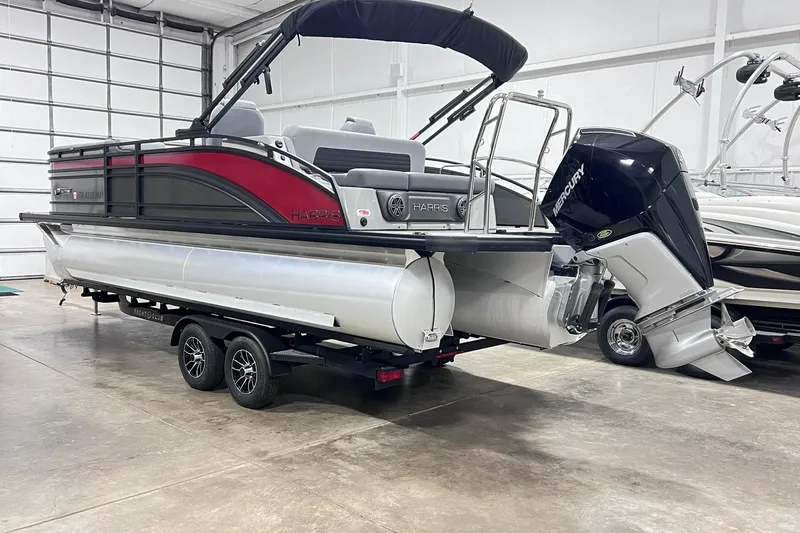 Slide: The Image of 2024 Harris Solstice 230 pontoon boat with Mercury outboard engine in a showroom. - 4