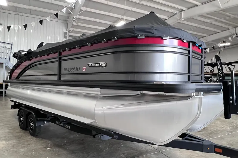 Slide: The Image of 2024 Harris Solstice 230 pontoon boat in showroom, covered and on trailer. - 6