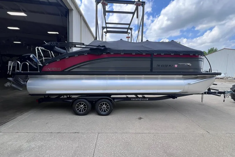 Slide: The Image of 2024 Harris Solstice 230 pontoon boat on trailer, parked outside a warehouse. - 9