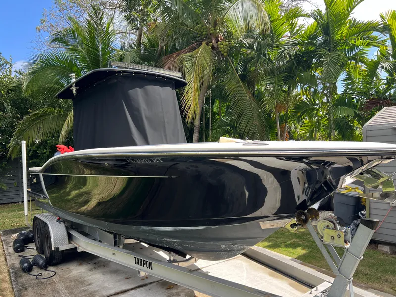 Slide: The Image of 2019 Scout 255LXF boat on trailer, surrounded by tropical palm trees. - 21