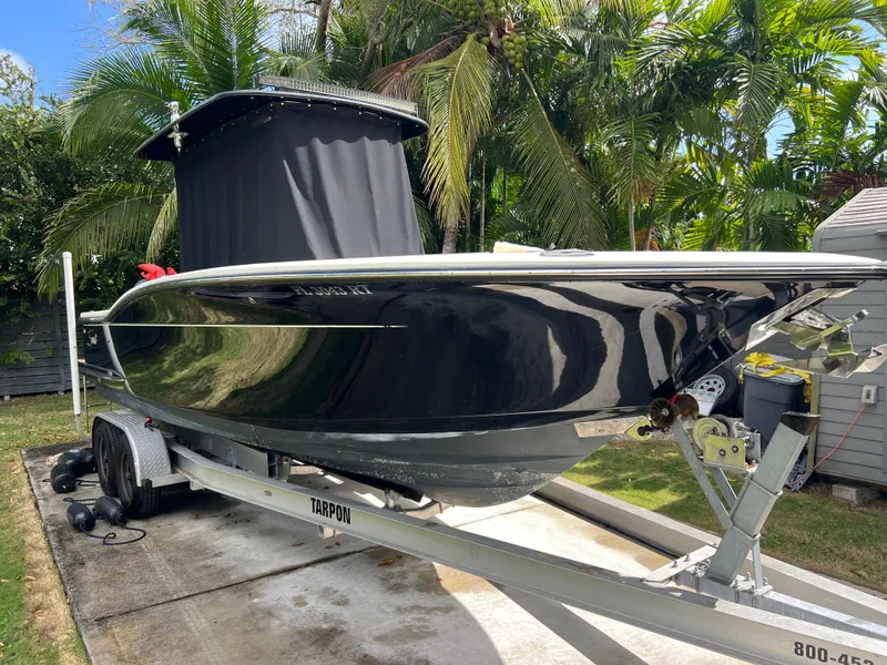 Slide: The Image of 2019 Scout 255LXF boat on a trailer in a tropical setting. - 22