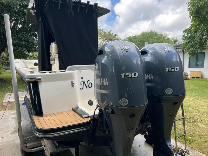 Slide: The Image of 2019 Scout 255LXF boat with twin Yamaha 150 engines, docked outdoors. - 28