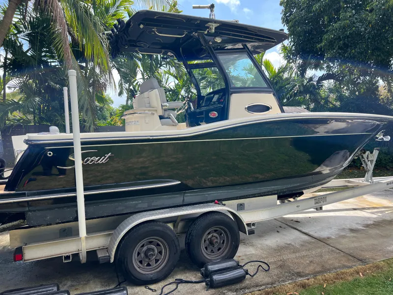Slide: The Image of 2019 Scout 255LXF boat on trailer, parked outdoors. - 3