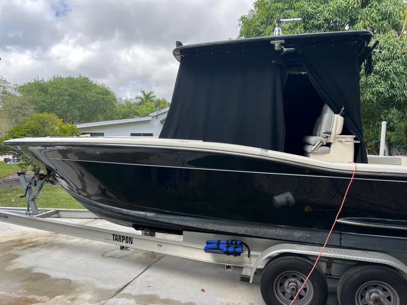 Slide: The Image of 2019 Scout 255LXF boat on trailer in driveway. - 30