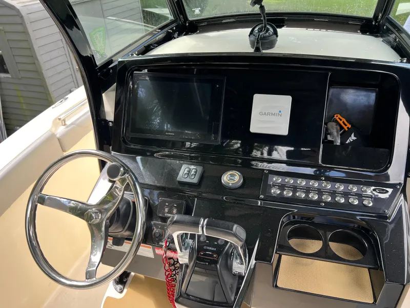 Slide: The Image of 2019 Scout 255LXF boat dashboard with Garmin navigation system and steering wheel. - 39