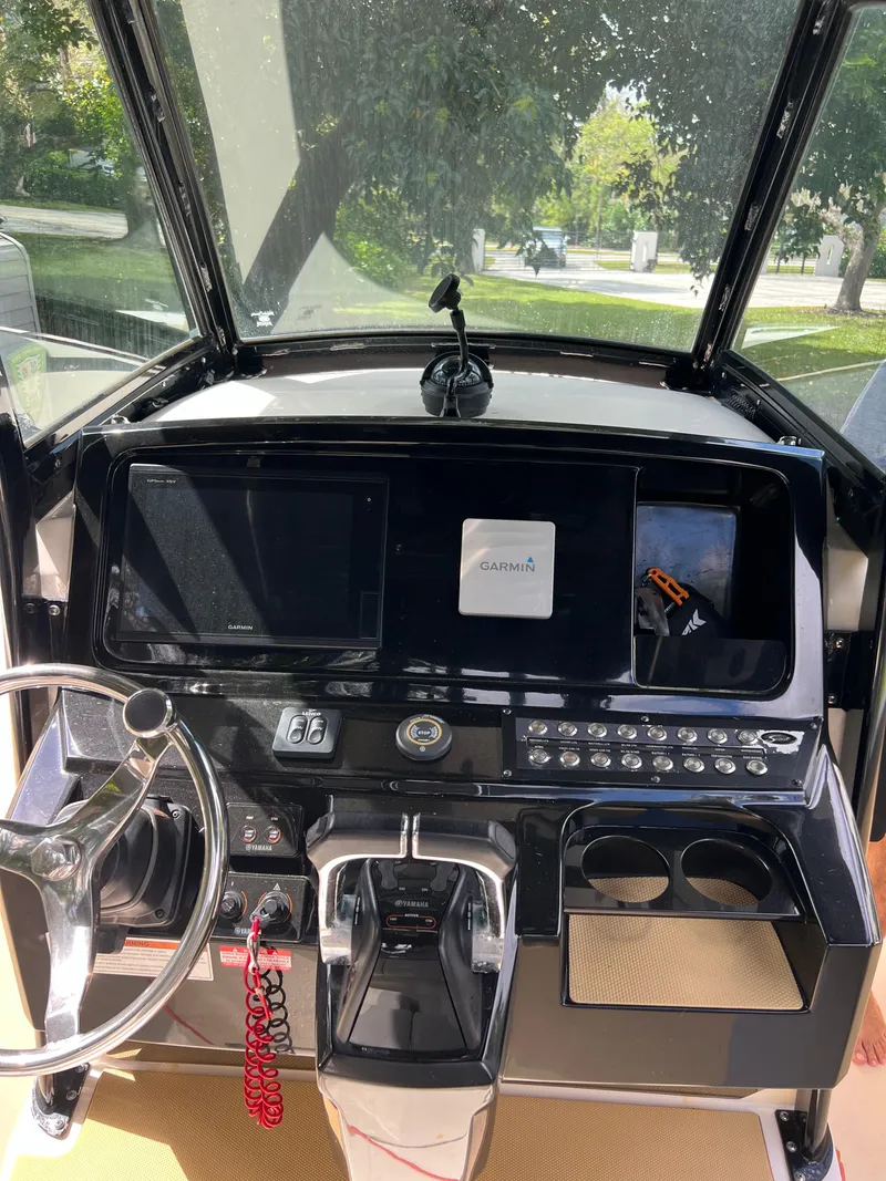 Slide: The Image of 2019 Scout 255LXF boat dashboard with steering wheel and navigation controls. - 40