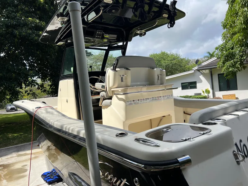 Slide: The Image of 2019 Scout 255LXF boat with center console and seating, parked outdoors. - 5