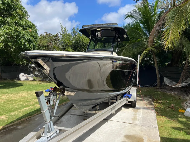 Slide: The Image of 2019 Scout 255LXF boat on trailer in tropical setting. - 6
