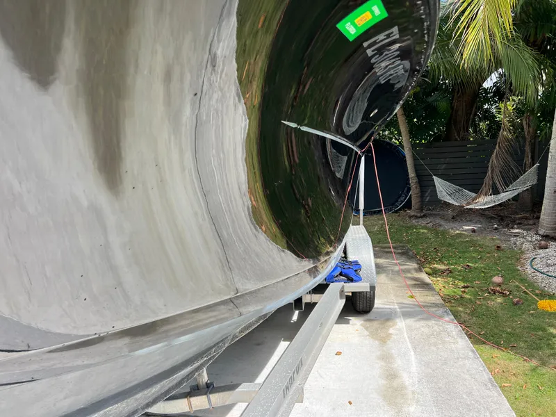 Slide: The Image of 2019 Scout 255LXF boat on trailer, side view, in a tropical setting. - 8