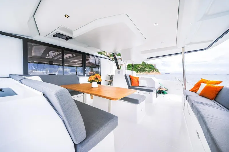 Slide: The Image of 2024 Fountaine Pajot Tanna 47 yacht interior with dining area and ocean view. - 10