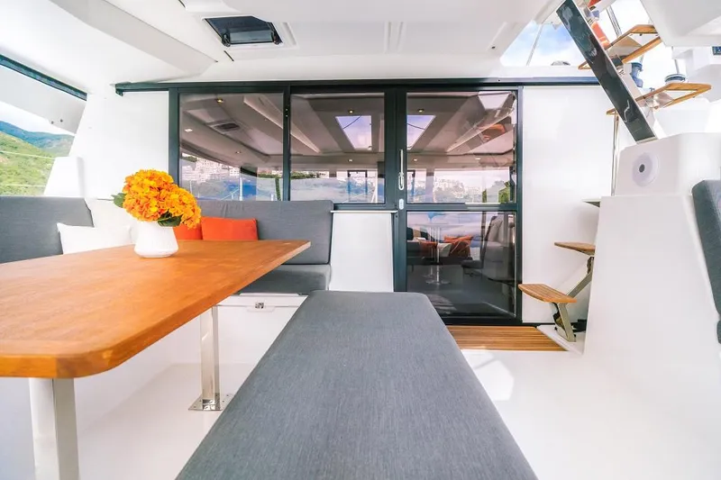 Slide: The Image of Modern interior of 2024 Fountaine Pajot Tanna 47 catamaran with dining area and floral centerpiece. - 15