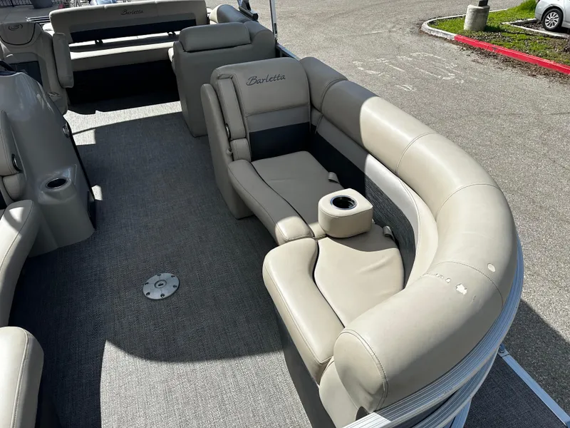 Slide: The Image of 2021 Barletta C22U pontoon boat with beige seating and cup holders. - 13