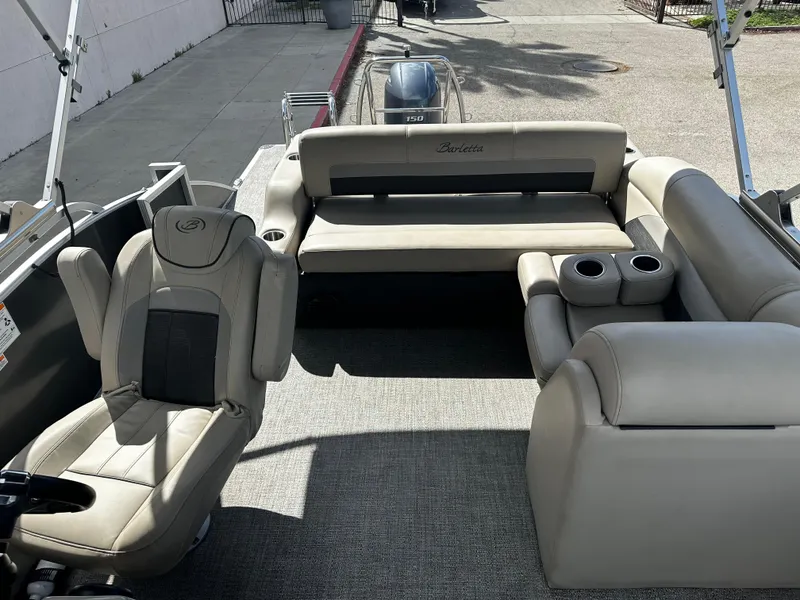 Slide: The Image of 2021 Barletta C22U pontoon boat interior with beige seating and cup holders. - 14