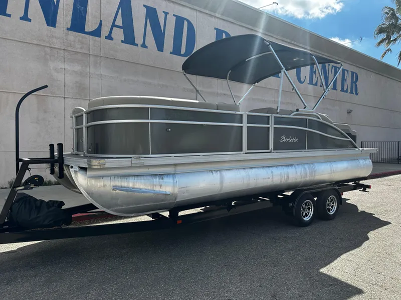 Slide: The Image of 2021 Barletta C22U pontoon boat on a trailer outside a marine center. - 9