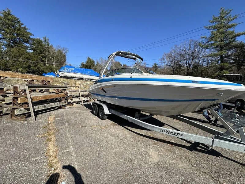 The Image of 2024 Crownline E Series E255 boat on trailer in outdoor storage area. - 0