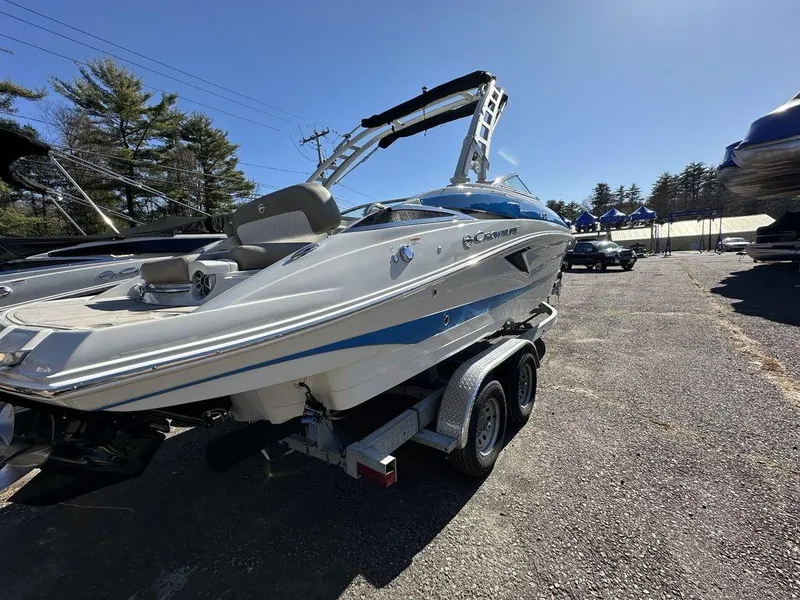 Slide: The Image of 2024 Crownline E Series E255 boat on a trailer in a sunny outdoor setting. - 12