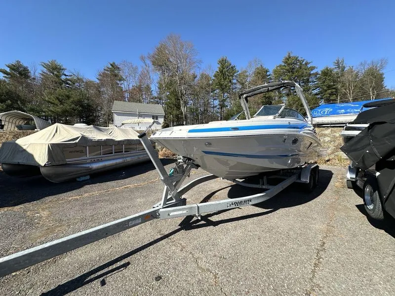 Slide: The Image of 2024 Crownline E Series E255 boat on a trailer in a parking lot. - 13