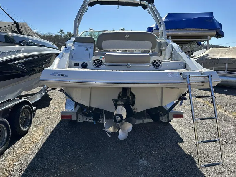 Slide: The Image of 2024 Crownline E Series E255 boat, rear view with ladder and propeller, parked on a trailer. - 15