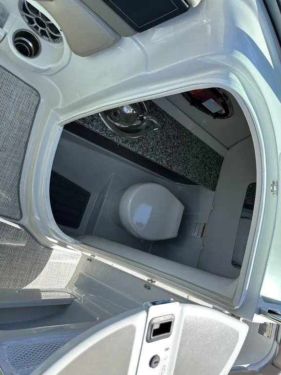 Slide: The Image of 2024 Crownline E Series E255 boat interior with a compact bathroom. - 6
