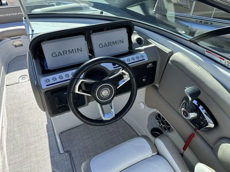 Slide: The Image of 2024 Crownline E Series E255 boat dashboard with dual Garmin displays and steering wheel. - 7