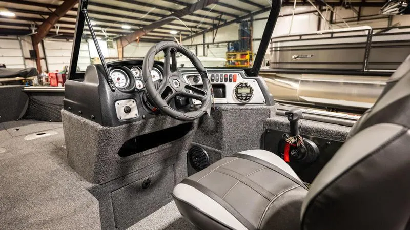 Slide: The Image of 2024 Lund 1875 Impact XS Sport boat interior with steering wheel and control panel. - 11