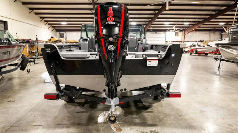 Slide: The Image of 2024 Lund 1875 Impact XS Sport boat with 150 HP engine in a warehouse. - 14