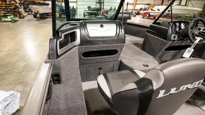 Slide: The Image of 2024 Lund 1875 Impact XS Sport interior view in a warehouse. - 20