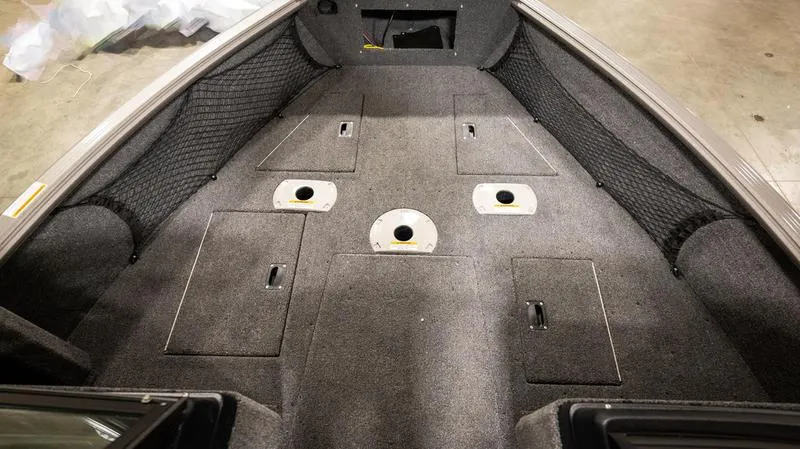 Slide: The Image of 2024 Lund 1875 Impact XS Sport boat interior with storage compartments and netting. - 22