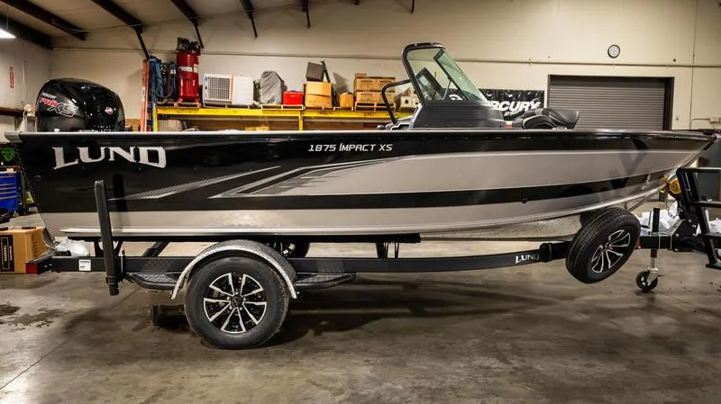 Slide: The Image of 2024 Lund 1875 Impact XS Sport boat in a garage, side view. - 23