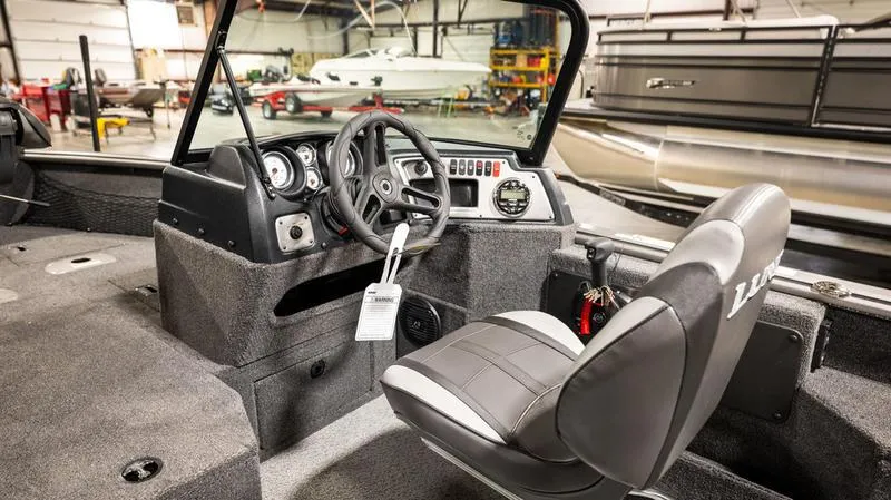 Slide: The Image of Interior of 2024 Lund 1875 Impact XS Sport boat, featuring steering console and seating. - 3