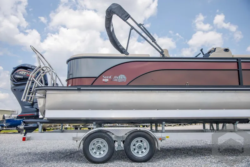 Slide: The Image of 2023 SunCatcher Select 322RC pontoon boat on a trailer under a blue sky. - 13