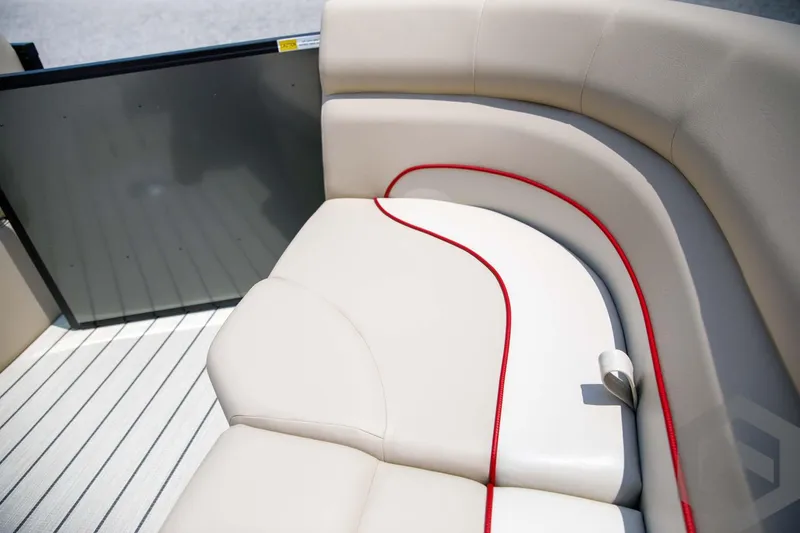 Slide: The Image of 2023 SunCatcher Select 322RC boat interior with beige and red-trimmed seating. - 23