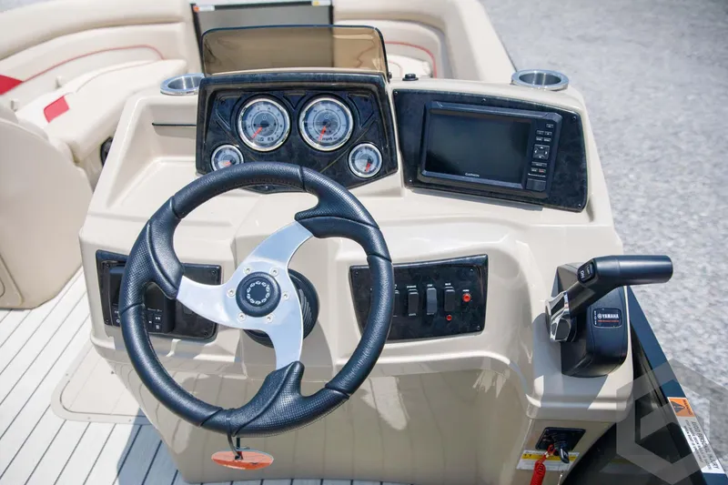 Slide: The Image of 2023 SunCatcher Select 322RC boat dashboard with steering wheel, gauges, and controls. - 34